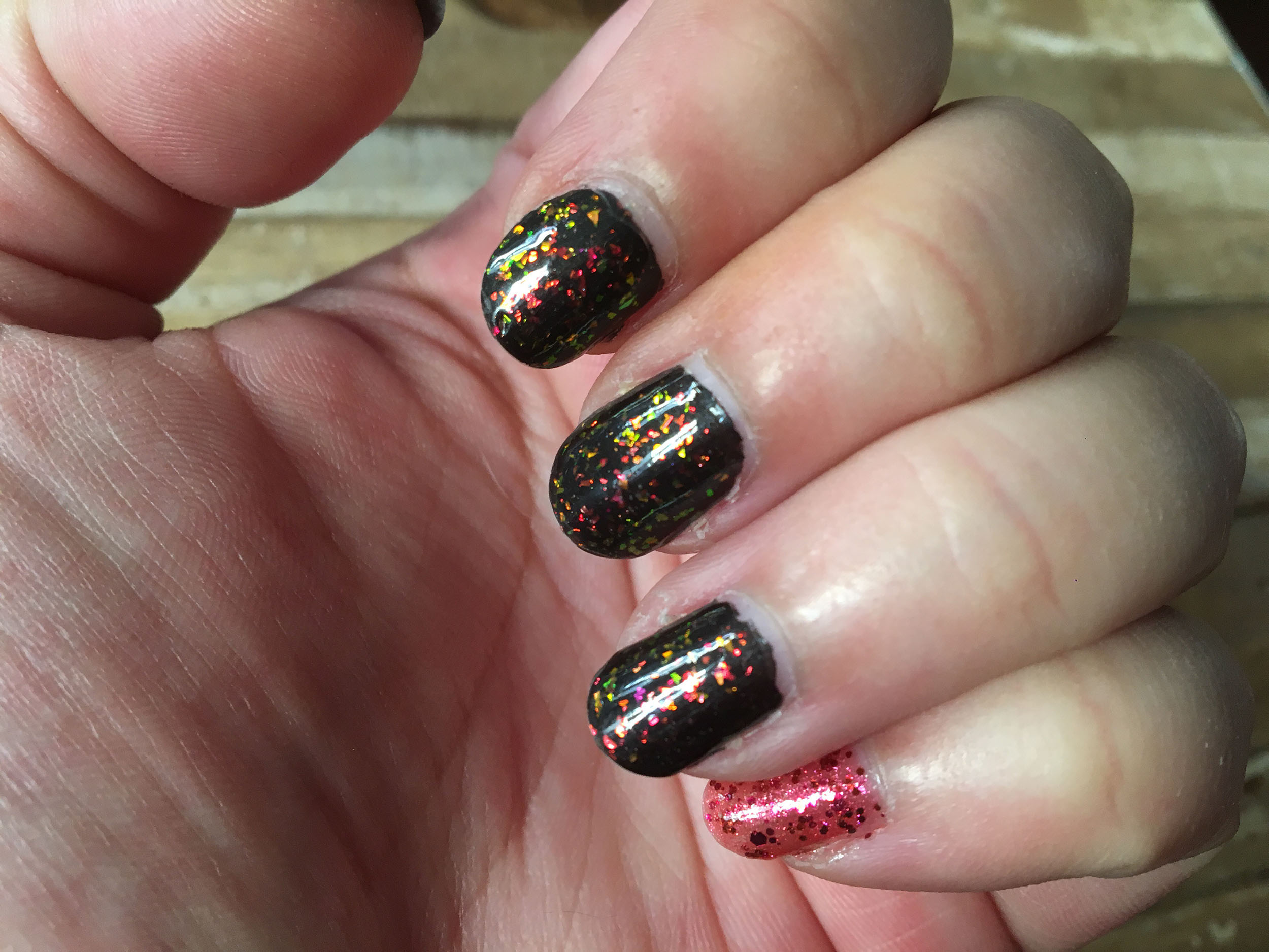 Vernis à paillettes posé sur les ongles de quelqu'un.